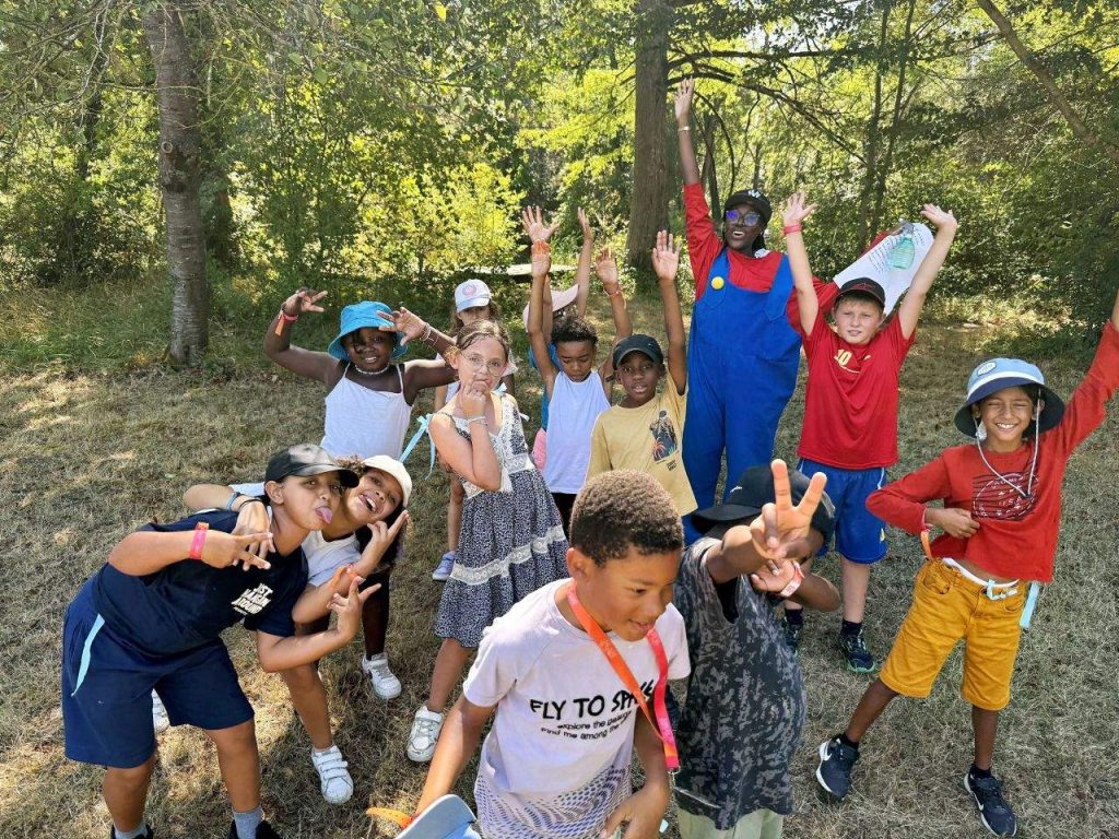 La Fête Continue 1 Enfants bras levés et tout sourire pendant un grand jeu en forêt, colonie de vacances d’été à Castelnaudary dans l’Aude